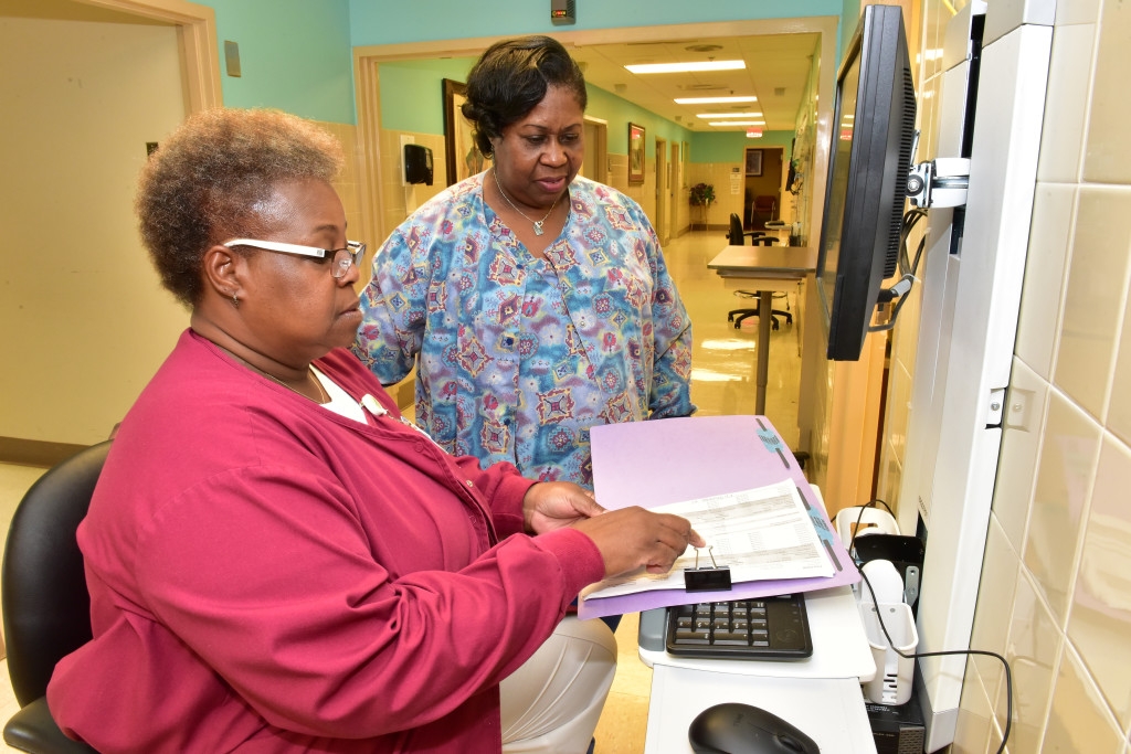 Minnie Winston, Charge Nurse in the Medical Home looks over a  chart with Willie Burks and LPN in the clinic. (Frank Couch / The Birmingham Times)