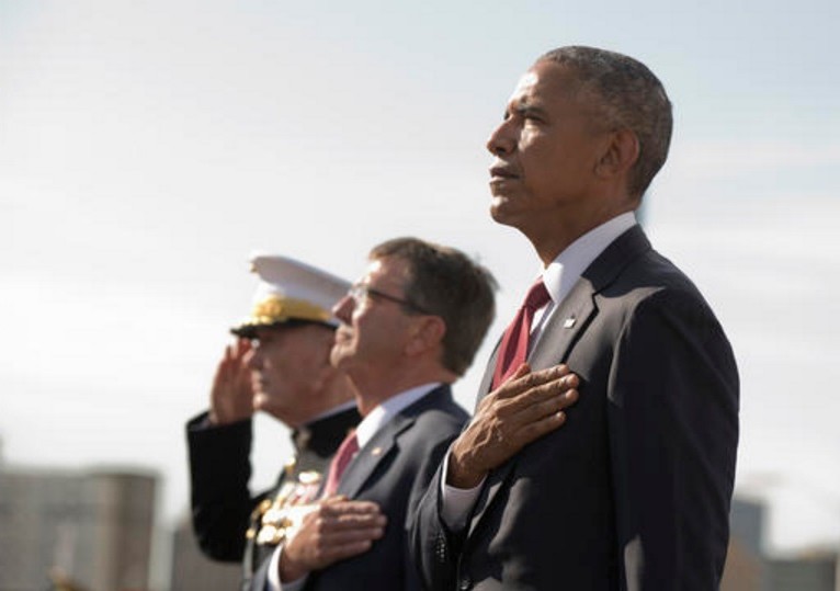 President Barack Obama, right, with Defense Secretary Ash Carter, center, and Chairman of the Joint Chiefs of Staff Gen. Joseph Dunford, stand at attention as the national anthem is played during a memorial ceremony at the Pentagon in Washington, Sunday, Sept. 11, 2016, to commemorate the 15th anniversary of the 9/11 terrorist attacks. (Manuel Balce Ceneta, Associated Press)