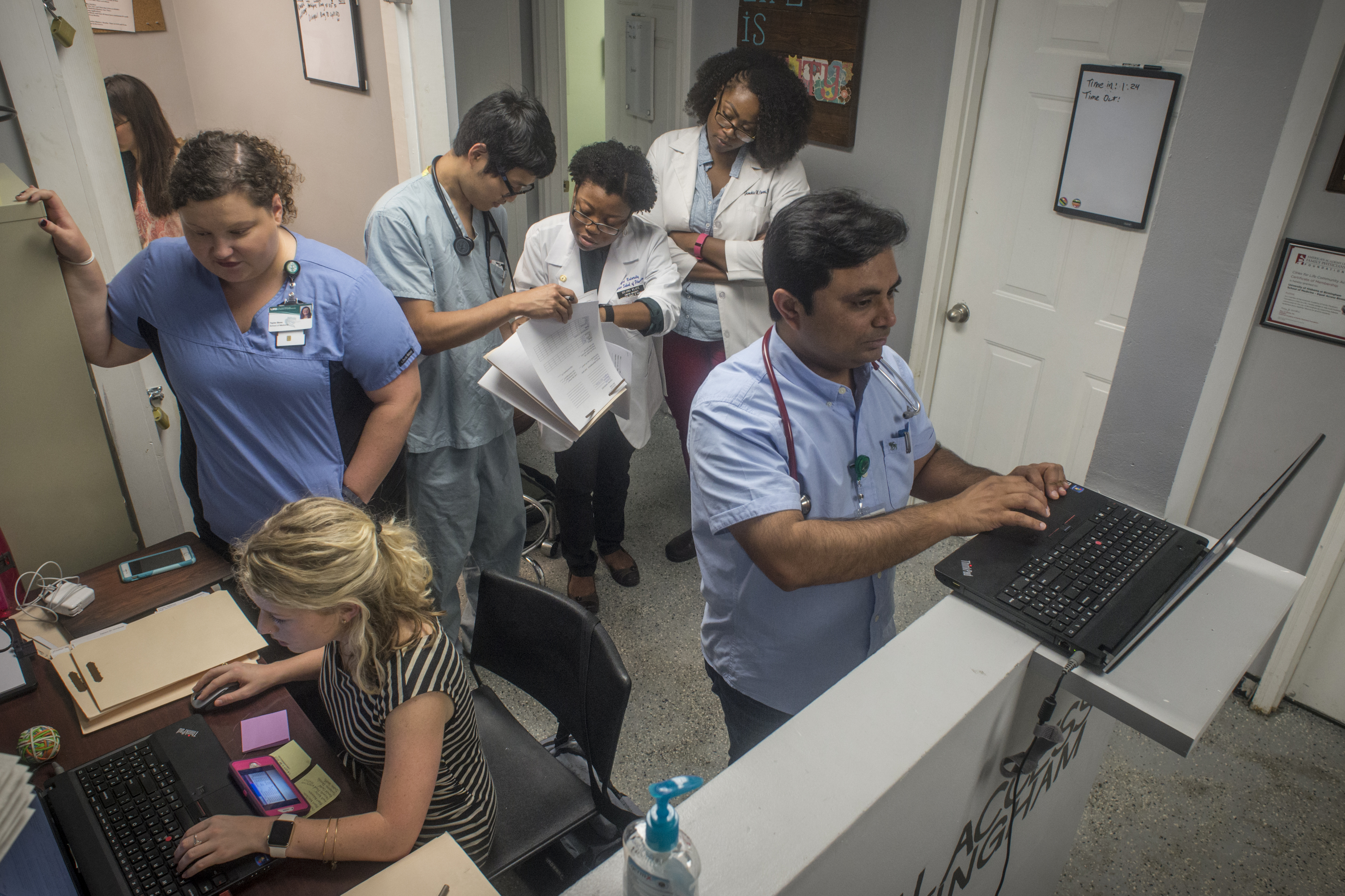 Dr. Gaurav Parmar does paper work in between helping UAB medical students at the Equal Access Birmingham clinic as they take medical histories before he sees the patients. (Walt Stricklin, special to The Times)