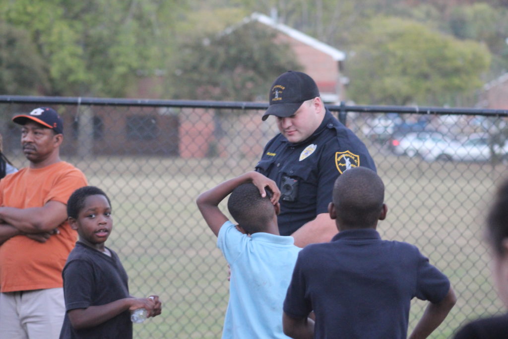 A Birmingham City Police officer interacts with children in the Gate City area. (Ariel Worthy, The Birmingham Times)