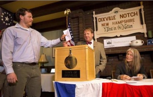 Dixville Notche's first voter Clay Smith drops his ballot into the box as moderator Tom Tillotson watches Tuesday, Nov. 8, 2016, in Dixville Notch, N.H. Democratic candidate Hillary Clinton beat Republican Donald Trump 4-2. (AP Photo/Jim Cole)