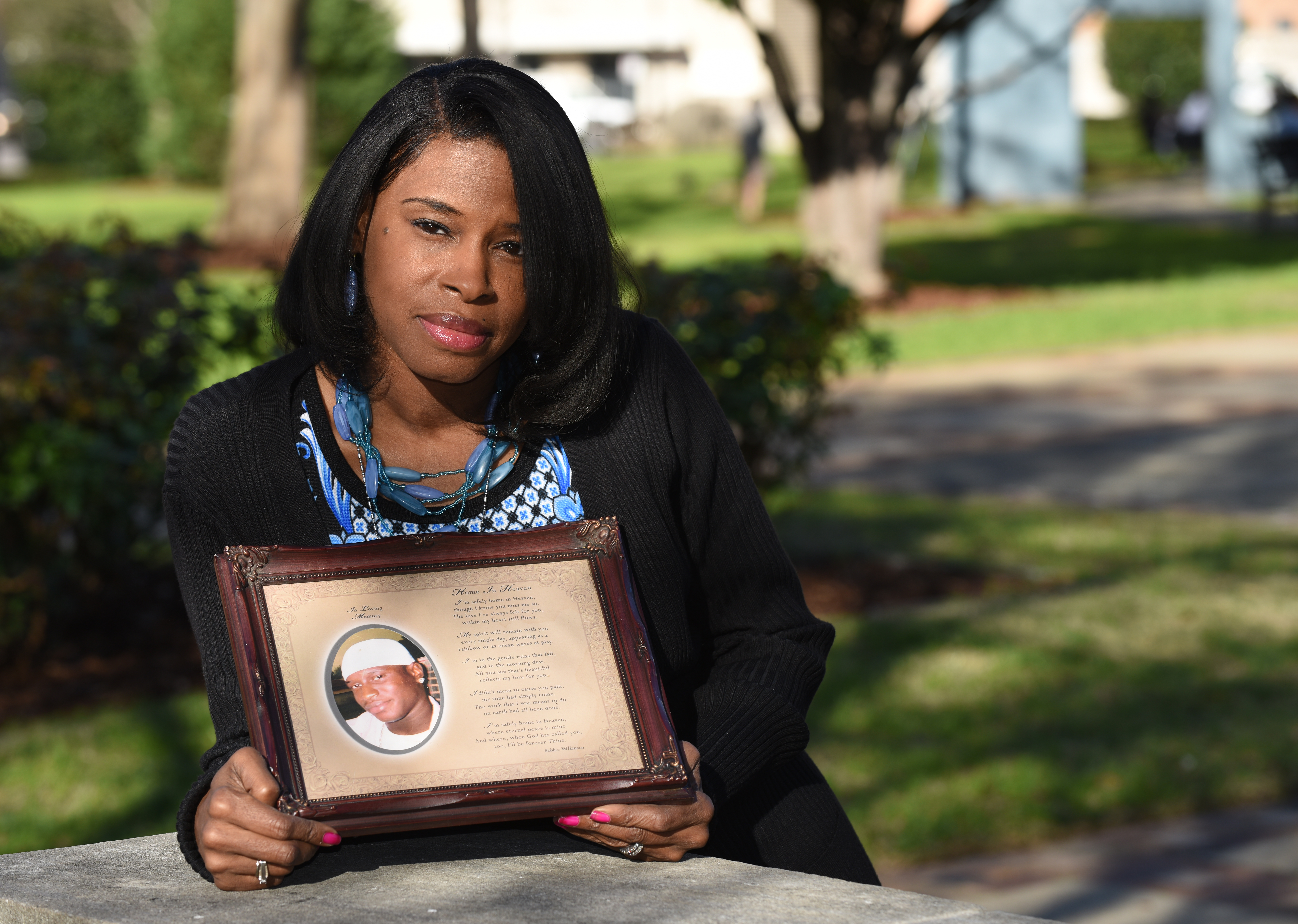 Carolyn Johnson holds a picture of her son Rodreckus Johnson who was killed as he pulled up to a birthday party. He was shot as he parked and was hit by a bullet fired by two people arguing, his killer has never been arrested. (Frank Couch / The Birmingham Times)