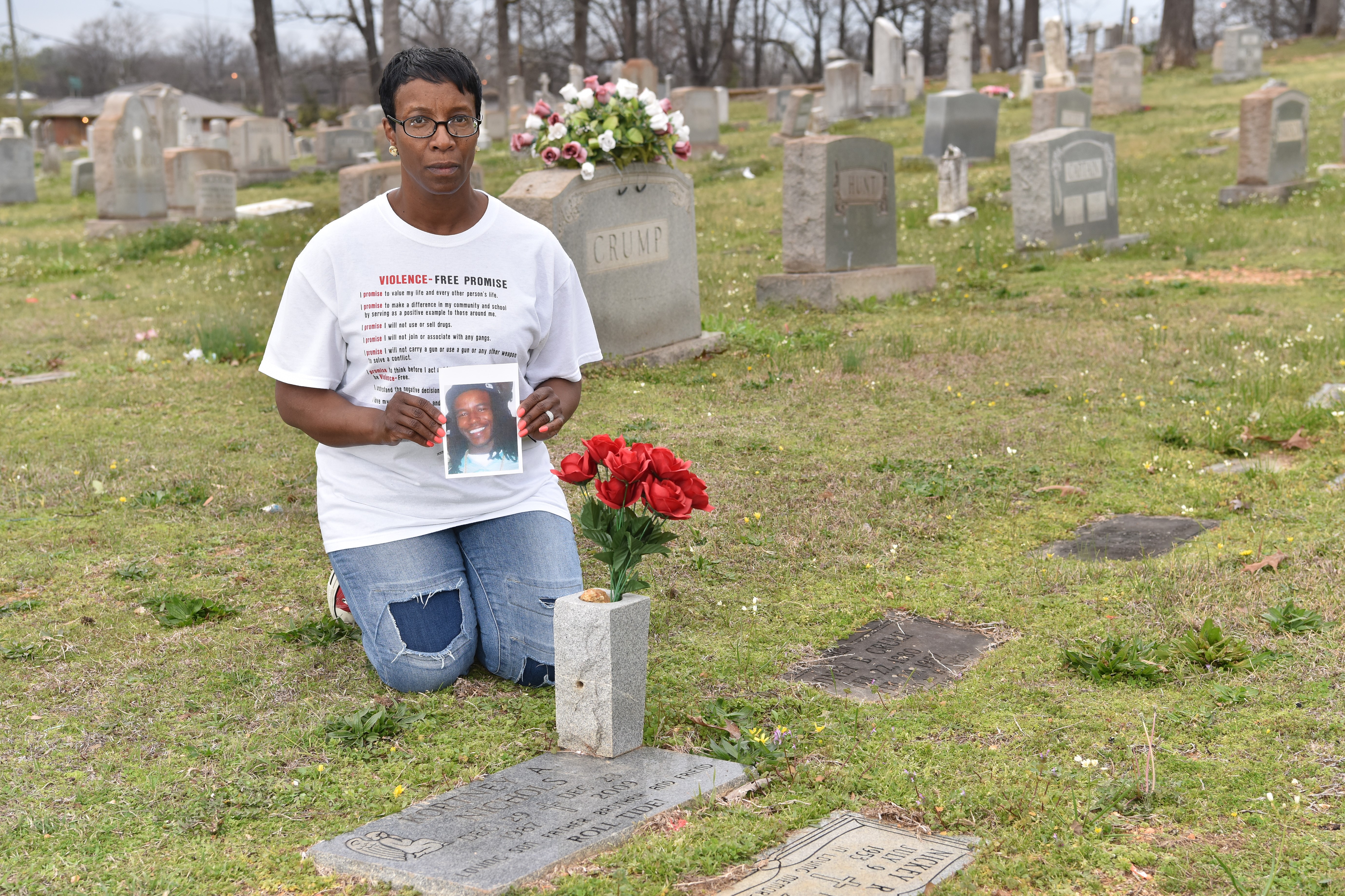 Shelisa Nichols holds a picture of her son Kortney Nichols at his graveside. Kortney was killed on December 23, 2009. (Frank Couch / The Birmingham Times)