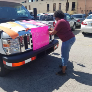Felicia Huntley, Interim Resident Services Administrator, decorates a housing authority bus Tuesday afternoon as teams prepare to visit multiple public housing communities to promote the Women's Empowerment Conference. (Darryl Washington, HABD photo)