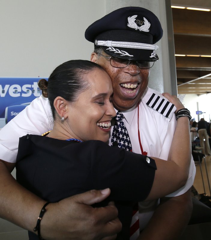 Airlines captain Louis Freeman, right, gets a hug from flight attendant Gisela Alvarez before he boards a jet fly his last flight for Southwest before his retirement in Dallas, Thursday, June 8, 2017. Freeman was the first African-American to become a chief pilot at a major U.S. airline and is retiring after a 36-year career that saw big changes in aviation. His most memorable flight carried the body of civil rights icon Rosa Parks. (AP Photo/LM Otero)