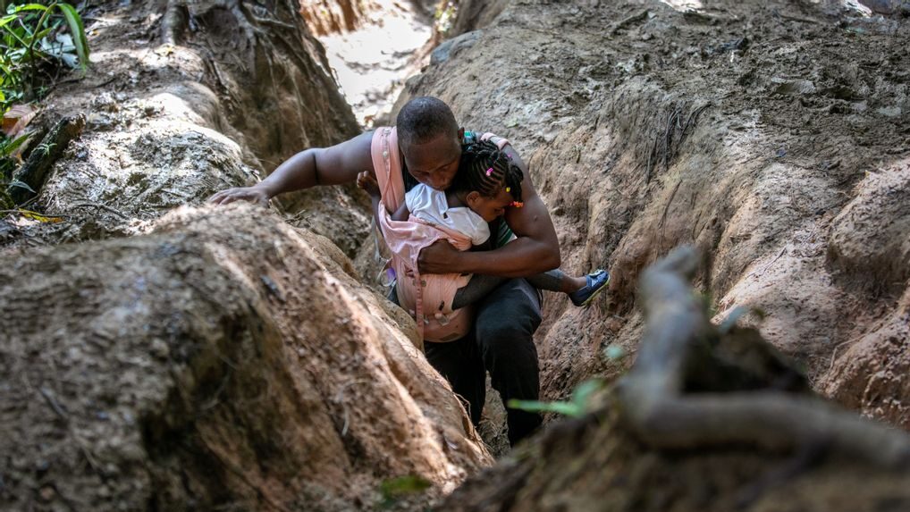 A Haitian father carries his daughter in the Darien Gap, between Colombia and Panama, on Oct. 5. It is the most dangerous passage for migrants walking through the Americas. They often hope to reach the United States, while others stay in Mexico. (John Moore/Getty Images)