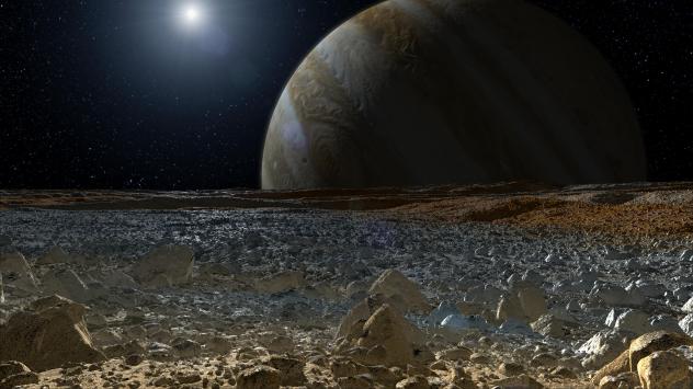 An artist's concept shows a simulated view from the surface of Jupiter's moon Europa. The planet Jupiter looms over the horizon. (NASA/JPL-Caltech)