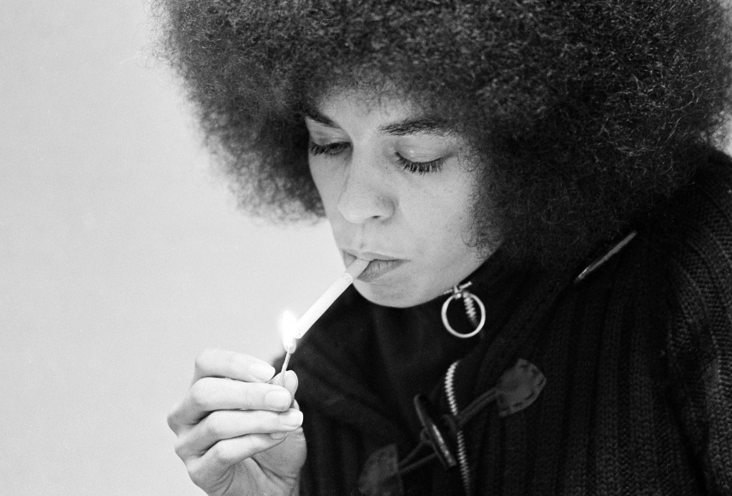 Angela Davis, black Communist jailed for more than a year on murder-conspiracy charges resulting from San Rafael courthouse slaying of a judge and three others, lights a cigarette as she talks during an exclusive interview with Associated Press reporters Edith Lederer and Jeannine Yoemans in tiny green interview room at Santa Clara County jail at Palo Alto, Dec. 27, 1971. (AP Photo/Sal Veder)