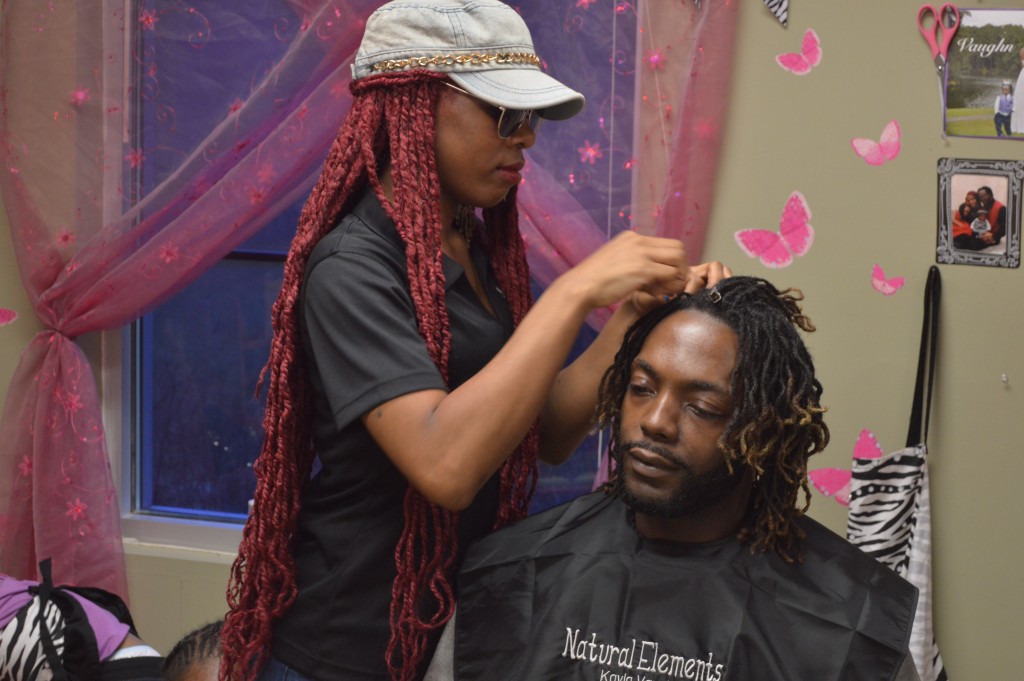 Natural hair stylist Kayla Vaughn re-locs her client Rico Vaughns hair. Kayla is a stylist at Natural Elements in Homewood. 