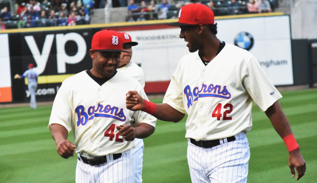  Eudy Pina (right) gives dap to teammate Marcus Lemon during evening to celebrate baseball great Jackie Robinson. (Solomon Crenshaw Jr. photo).