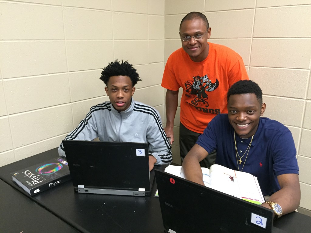 Huffman High science teacher with physics students Ronald Youngblood, left, and James Mullins on the newly donated laptops from Computers for Learning. Sanders, sponsor of the Robotics Team researched ways to secure funding to advance technology learning for students at his school. (Chanda Temple Photo, SPECIAL TO THE TIMES)