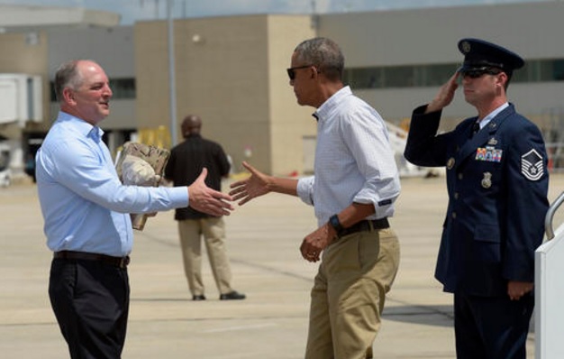 President Barack Obama reaches to shake hands with Louisiana Gov. John Bel Edwards, after arriving on Air Force One at Baton Rouge Metropolitan Airport in Baton Rouge, La., Tuesday, Aug. 23, 2016. Obama is traveling to the area to survey the flood damage. (Susan Walsh, Associated Press) 