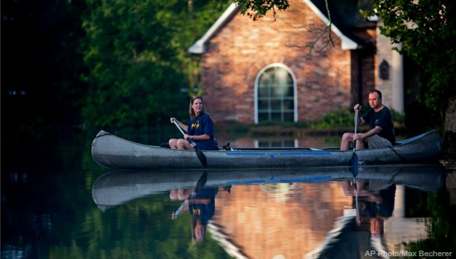 Danny and Alys Messenger canoe away from their flooded home after reviewing the damage in Prairieville, La., Tuesday, Aug. 16, 2016. As waters begin to recede in parts of Louisiana, some residents struggled to return to flood-damaged homes on foot, in cars and by boat. (Max Becherer, The Associated Press)