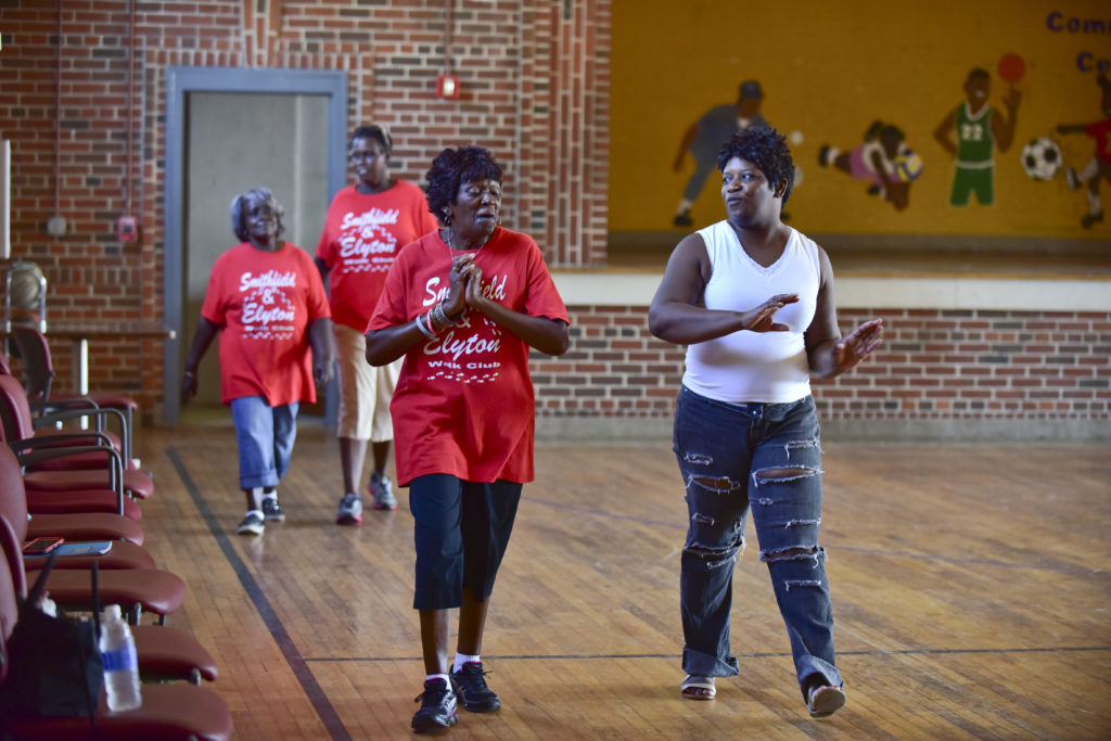 From left, Gloria Sanders, Melinda Ruffin, Delia Mitchell and Tracey Moore take a lap around the gym during Walk Club. (Frank Couch, The Birmingham Times)