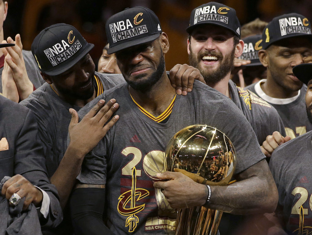 In this June 19, 2016, file photo, Cleveland Cavaliers forward LeBron James, center, celebrates with teammates, including Kevin Love, third from left, after Game 7 of basketball's NBA Finals against the Golden State Warriors in Oakland, Calif. James delivered on his personal pledge to bring home a title in June. (Marcio Jose Sanchez, Associated Press, File)
