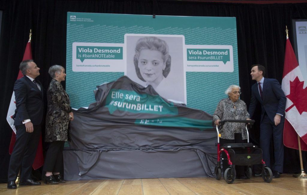 Bank of Canada Governor Stephen Poloz, left, Minister of Status of Women Patricia Hajdu, Minister of Finance Bill Morneau, right, and Wanda Robson unveil an image of Viola Desmond who will be featured on the new Canadian ten dollar bill during a ceremony in Gatineau, Quebec, Canada Thursday. Robson is Viola Desmond’s sister. (Adrian Wyld, Associated Press) 