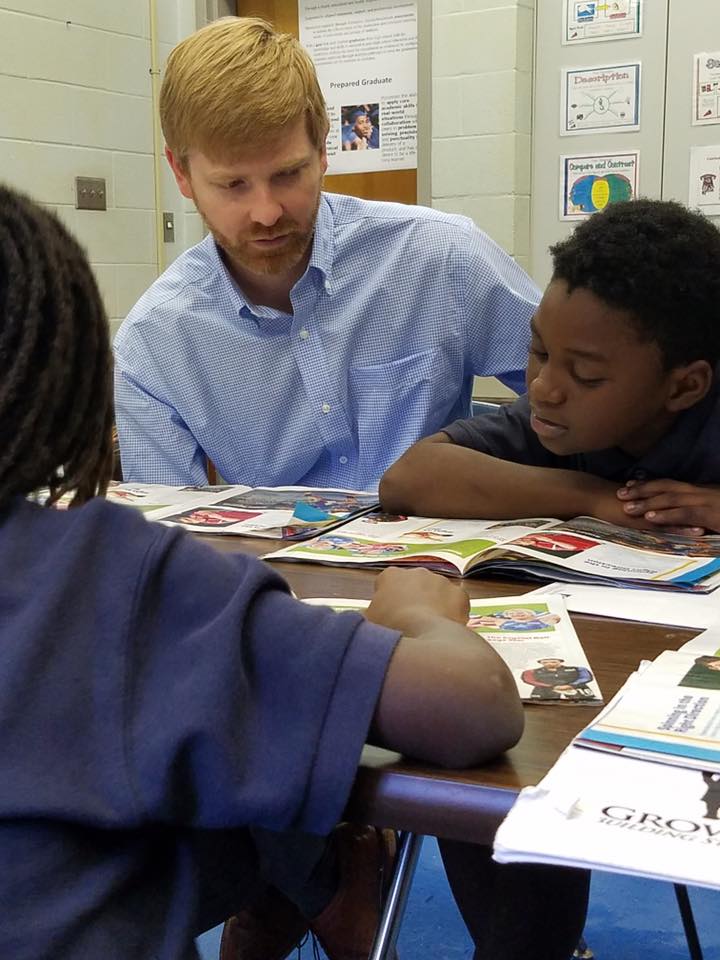 Tal Simpson, attorney at Balch & Bingham LLP, reads a magazine with one of the Growing Kings students. (Provided photo)