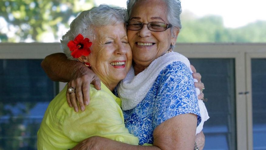 In this Friday, Nov. 18, 2016 photo, Joan Rodby, 85, left, and Emma Veary, 86, hug during a reunion in Makawao, Hawaii. After the Pearl Harbor attack, their schools required them to carry gas masks with them at all times. (Rick Bowmer, Associated Press) 