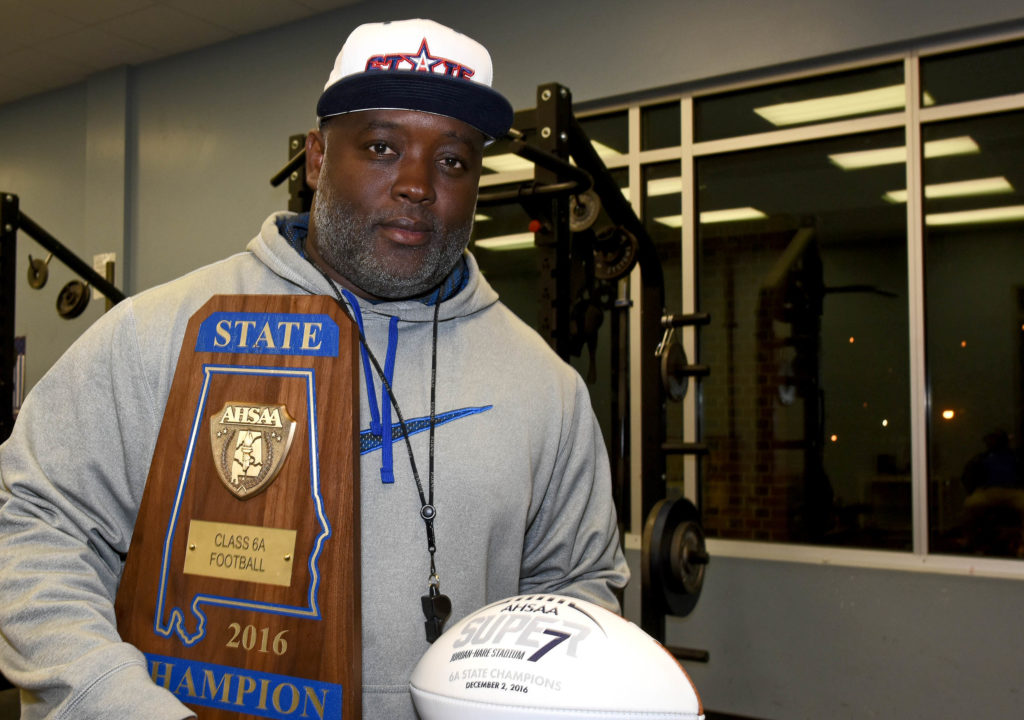 Coach Rueben Nelson Jr. cradles the championship trophy and football he received after his Ramsay Rams defeated Opelika 21-16 in Jordan-Hare Stadium  to win the Class 6A Alabama High School Athletic Association state football championship on Friday, Dec. 2, 2016. (Solomon Crenshaw Jr., special to The Times)