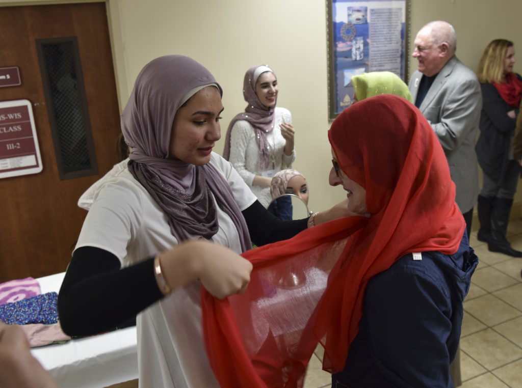 Tala Samour helps Karen Arnold with a Hajib, a traditional head covering as part of the information session. (Frank Couch,The Birmingham Times )