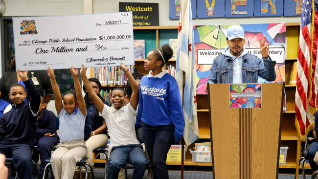 Chance The Rapper, right, announces a gift of $1 million to the Chicago Public School Foundation during a news conference at the Westcott Elementary School, Monday in Chicago. The Grammy-winning artist is calling on Illinois Gov. Bruce Rauner to use executive powers to better fund Chicago Public Schools. (Charles Rex Arbogast, Associated Press) 