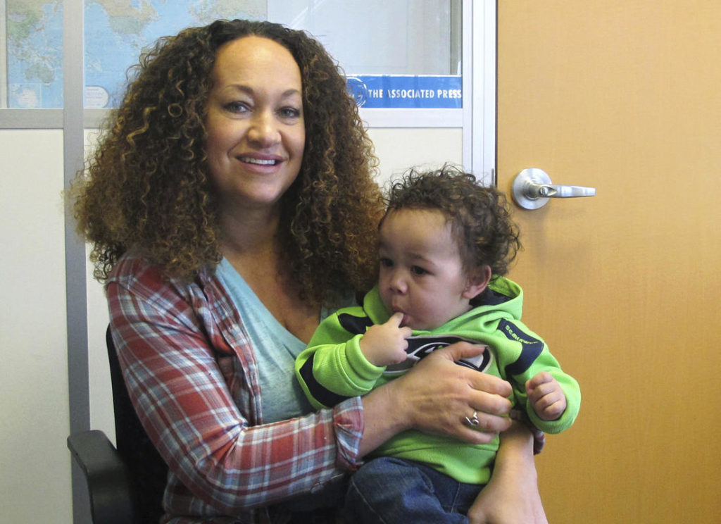 In this March 20, 2017 photo, Rachel Dolezal poses for a photo with her son, Langston in the bureau of the Associated Press in Spokane, Wash. Dolezal, who has legally changed her name to Nkechi Amare Diallo, rose to prominence as a black civil rights leader, but then lost her job when her parents exposed her as being white and is now struggling to make a living. (Nicholas K. Geranios, Associated Press)