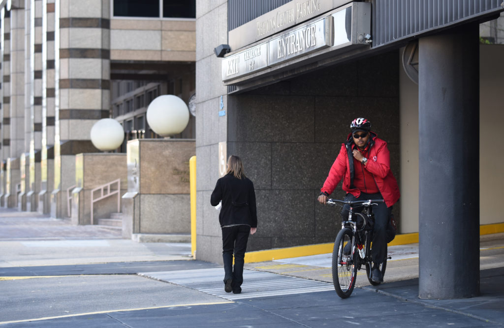 CAP officer Eugene McCoy rides a bike on patrol after helping a motorist unlock a car in a parking deck. (Frank Couch, The Birmingham Times)
