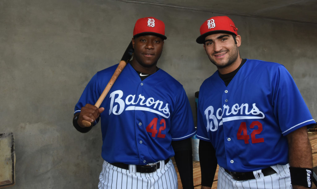 Designated hitter Keon Barnum, left, and first baseman Nick Basto share a moment in the dugout before their Jackie Robinson Day game against the Montgomery Biscuits on Saturday, April 15, 2017. Barnum opened the scoring with a home run as the Barons won, 5-2, with all members of the home team wearing No. 42. (Solomon Crenshaw Jr., for The Birmingham Times)