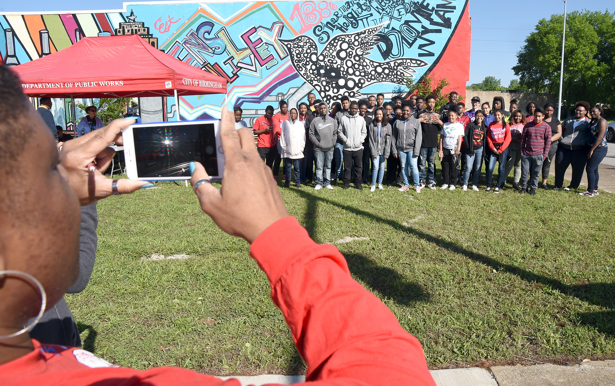 Teacher Maria Reese takes a picture of G.W. Carver High School students who participated in a clean up of the downtown Ensley area of Birmingham, Ala., Saturday, May 6, 2017. (Photo by Mark Almond)