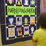 Ella Quick Thomas of Pelham admires a Halloween quilt