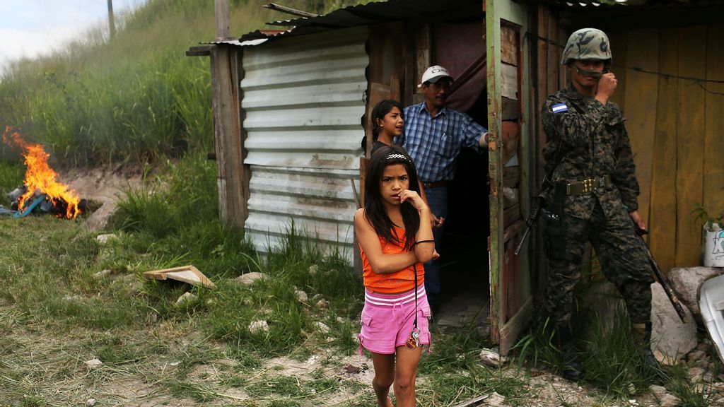 A young girl and her family stand by their home as police and the army force them and their neighbors to dismantle the shanty town. The government claimed the settlement was illegal on July 20, 2012, in Tegucigalpa, Honduras. Living conditions in the country are rated among the worst in the world. (Spencer Platt/Getty Images)