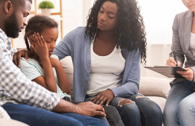 Little black girl and her parents at psychologist consultation