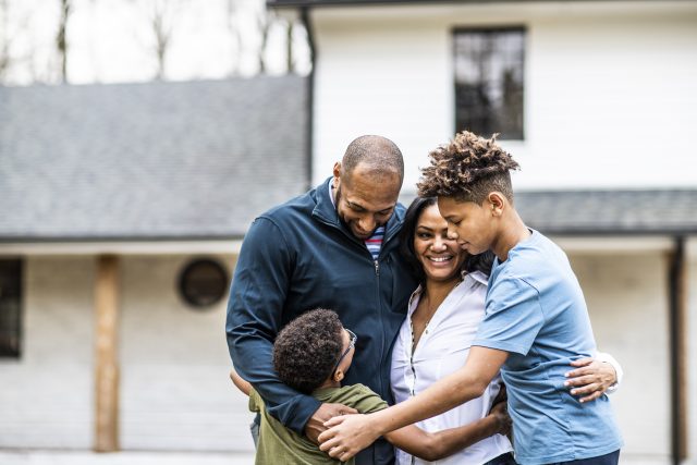Portrait of family in front of residential home