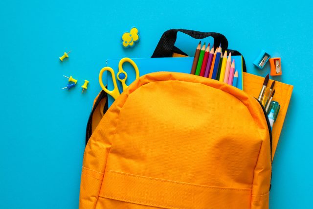 Back to school concept. Backpack with school supplies. Top view.